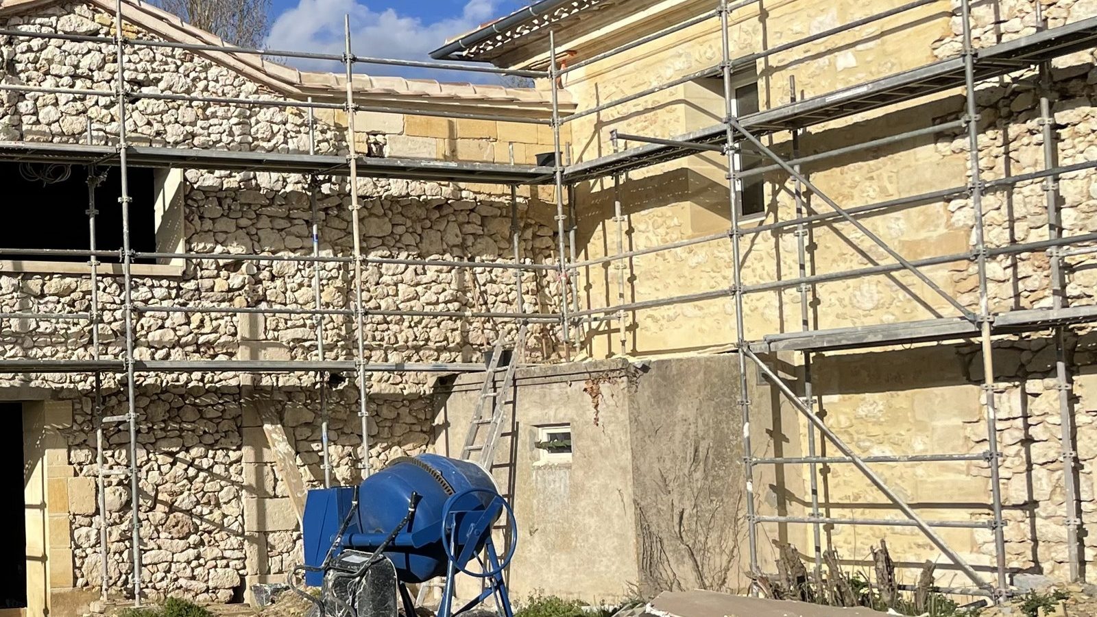 Façade de maison en pierre sous échafaudage pendant un ravalement