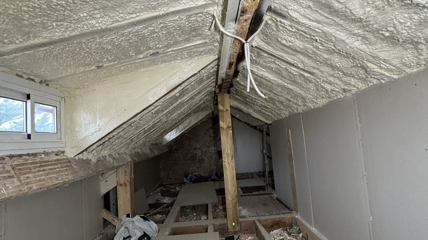 Combles en cours d'isolation, mousse projetée sous la toiture